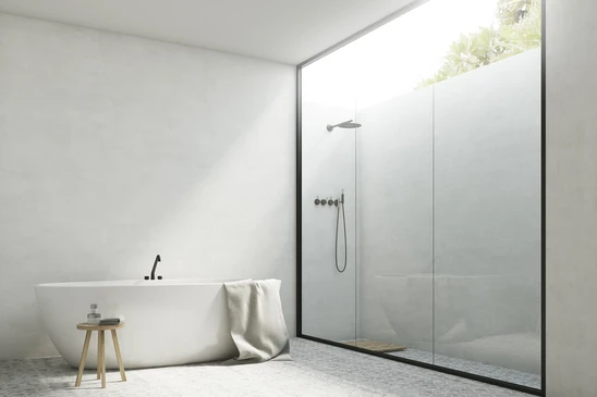 Salle de bain moderne minimaliste avec baignoire îlot blanche et douche à l'italienne séparée par cloison vitrée noire