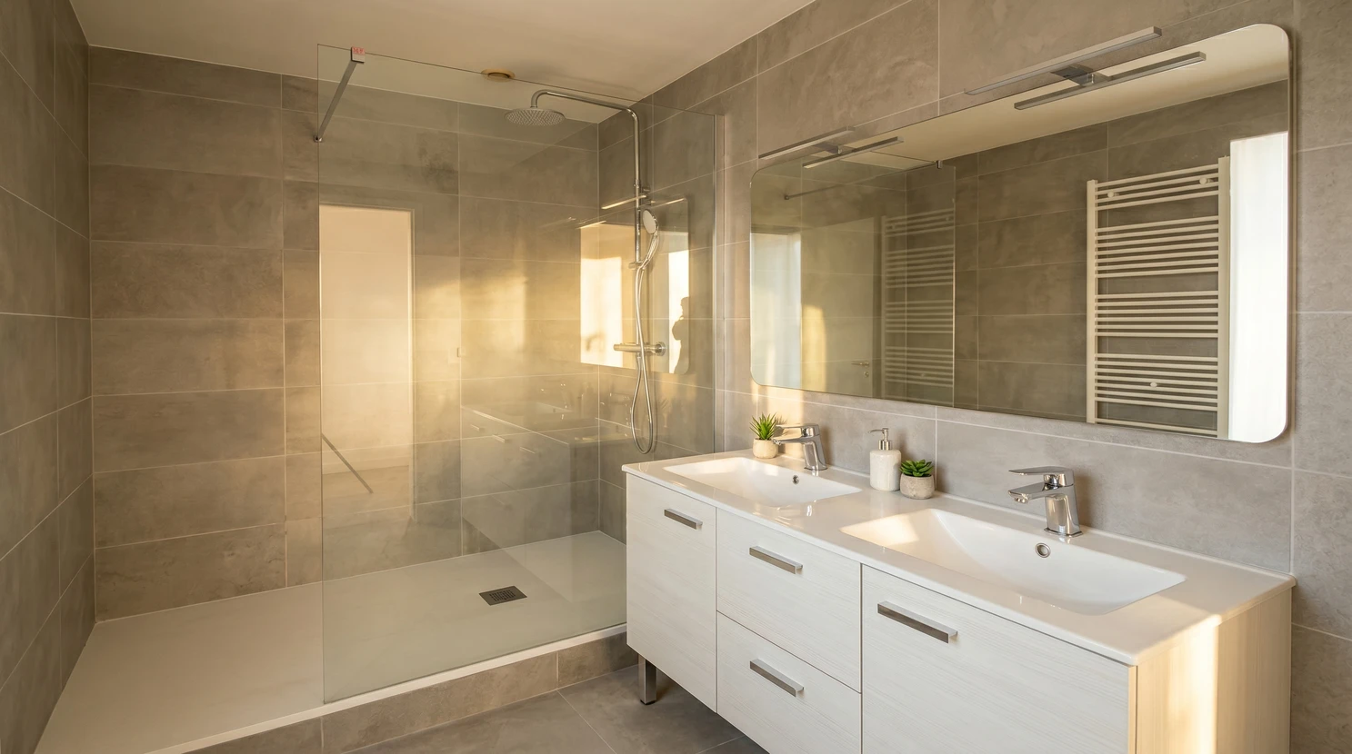 Salle de bain moderne luxueuse avec douche &agrave; l'italienne vitr&eacute;e, baignoire d'angle encastr&eacute;e, double vasque sur meuble suspendu blanc